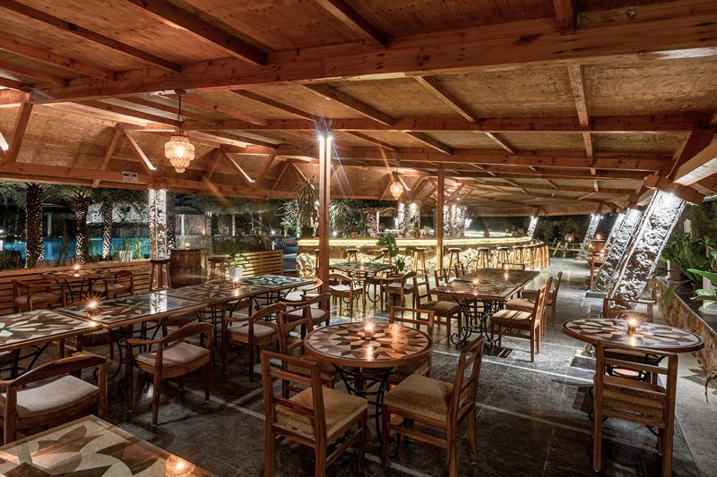 Lush open-air dining pavilion set with warm buffet chafing dishes and salad bar